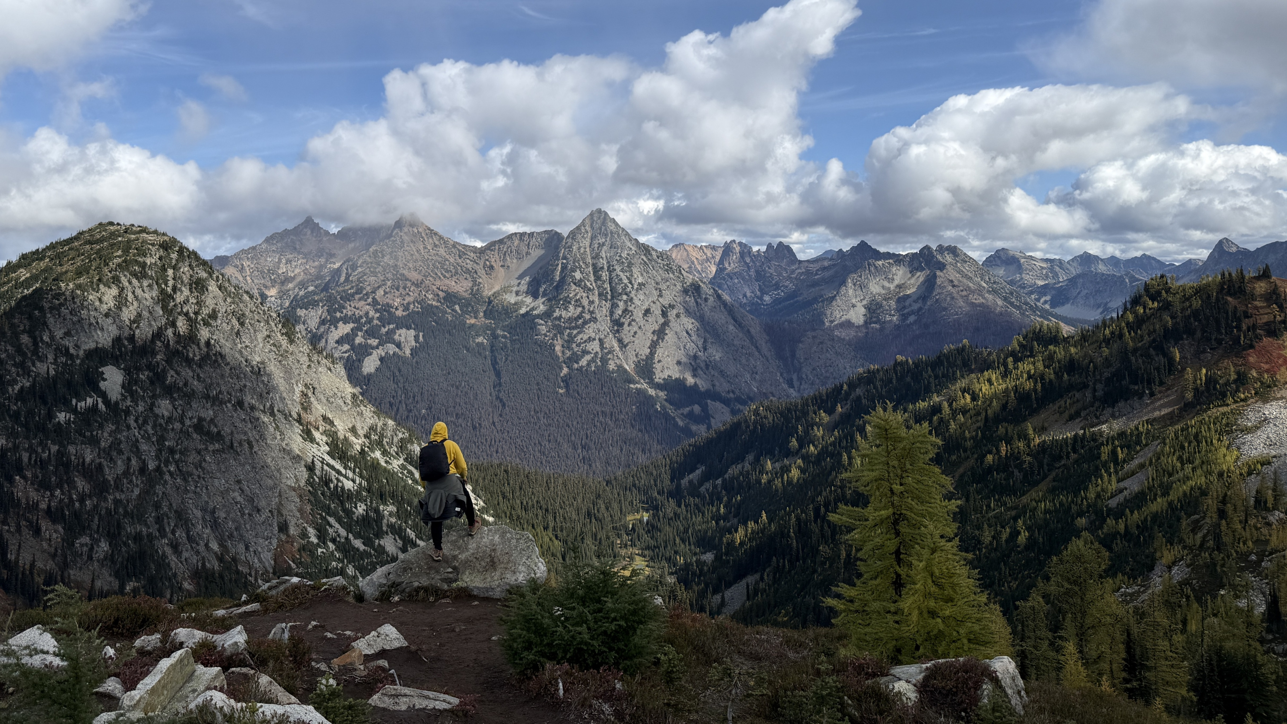 A picture of North Cascades national park with me standing at the edge in a yellow hoodie.